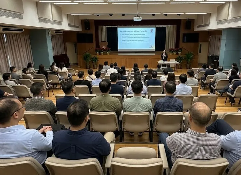 禮堂內大批同工出席講座，舞台大螢幕展示「Parent Engagement & School Partnership」家校協作主題簡報。